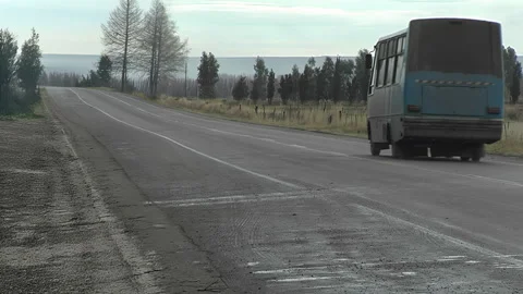 Bus Driving Away on Empty Rural Highway Stock Footage 331543824