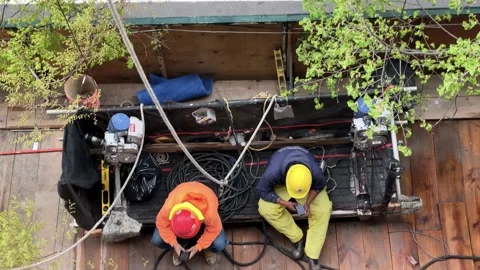 Bus driving past construction workers taking break on mobile phones texting Stock Footage 152649579