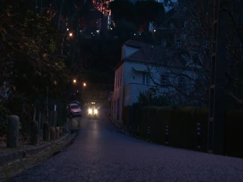 Bus driving by small calm road in tourist town in mountains, dusk evening light Video stock 74601878