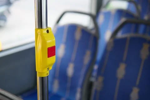 Bus interior with yellow stop button and empty seats Stock Photos