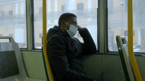 On the bus with mask - tired black man comes home tired from work by bus Stock Footage 146834066