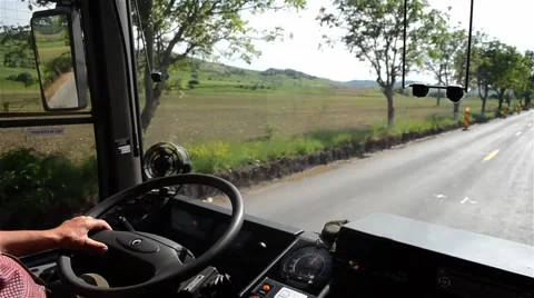 Bus moving on a road with two lanes bordered by trees Stock Footage 63563333