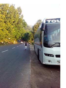 A bus parked on the road side going towards hills in India during summer. Photos