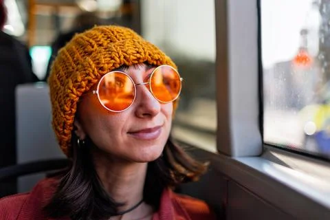 Bus passenger looking out the window. Beautiful young woman going to work b.. Stock Photos