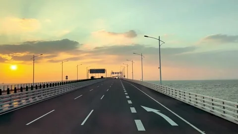 Bus road trip crossing straits and open ocean under sunset sky Vídeos de archivo 287590478