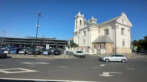 Bus side window view travelling in Kaunas city past white church. Stock Footage 279323612