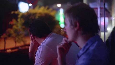 Bus station two men wait the bus on blurred road with cars in night city Stock-Footage 80230679