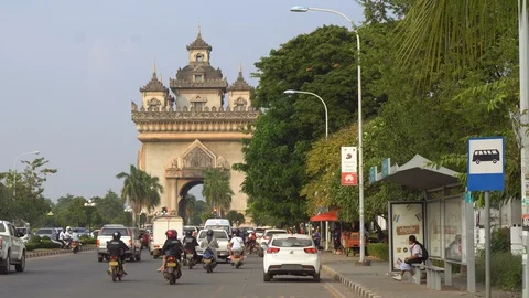 Bus Stop and Traffic on Main Road With Patuxai Archway in Vientiane, Laos Stock Footage 128602864