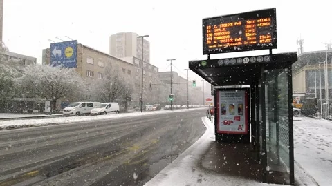 Bus stop arrivals information board in the city center in the snow Stock Footage 153282548