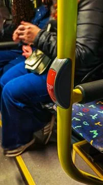 Bus stop button with passengers in the background, public transport concept Stock Photos