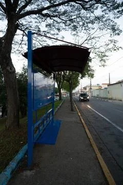 Bus stop with cover and empty steel seat in quiet neighborhood Foto stock