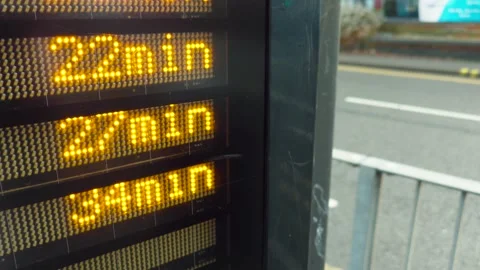 Bus stop digital display counting down arrival time in urban street. LED numbers Video stock 328358869