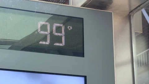 Bus stop thermometer displaying nearly 100°F during heatwave in East Village NYC Video stock 342781082