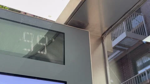 Bus stop thermometer displaying nearly 100°F during heatwave in East Village NYC Vídeo Stock 342781535