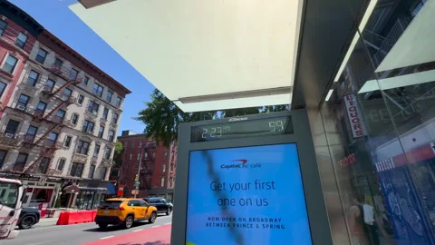 Bus stop thermometer displaying nearly 100°F during heatwave in East Village NYC Vídeos de archivo 342781780
