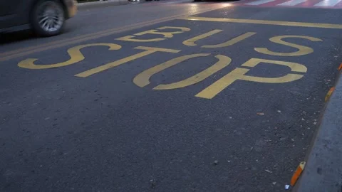 BUS STOP traffic sign printed on an asphalted bus lane with yellow paint. Vidéo 256381557