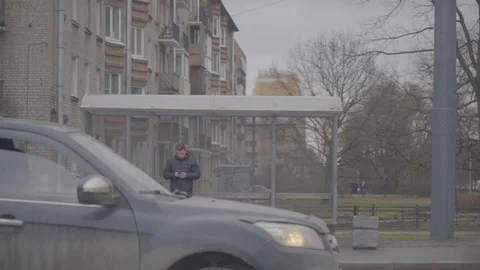BUS STOP YOUNG MAN MAN PHONE CARS Stock Footage 124730964