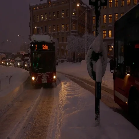 Bus stuck in snow causing traffic in streets of the city in a snowy day at night Stock Footage 69555429