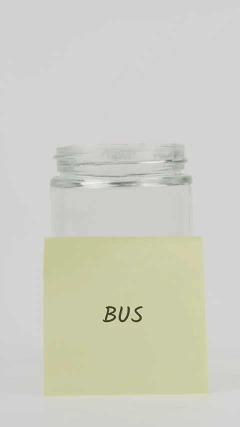 Bus text or word on yellow sticky note attached to glass jar with hand Stock Footage 311684122
