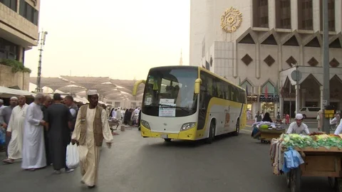 Bus tries to get through Medina market streets, passersby wave at camera Stock Footage 86760222