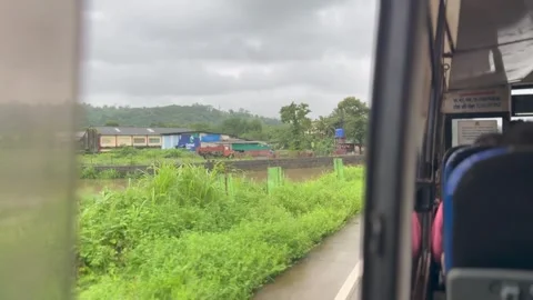 Bus window seat and experiencing India's country side during monsoon season Stock Footage 337547786