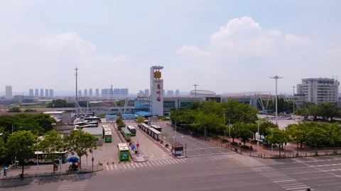 Buses and terminal clock tower across a city intersection in Huizhou Video stock 347466221