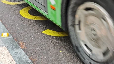 Buses driving over a bus stop sign painted on asphalt Stockbeeldmateriaal 308036212