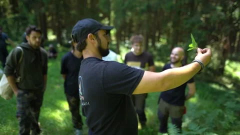 Bushcraft instructor demonstrating plant knowledge during outdoor survival camp Vídeo Stock 331342616