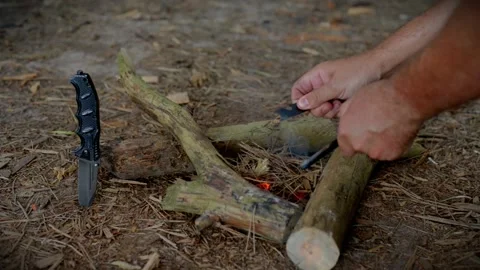 Bushcraft survivalist using a ferro rod fire starter in the forest woods Stock Footage 341682628