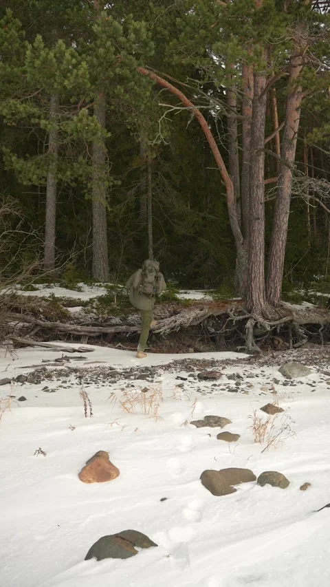 A bushcrafter with a backpack is entering a winter forest. The traveler is Видео 310319177