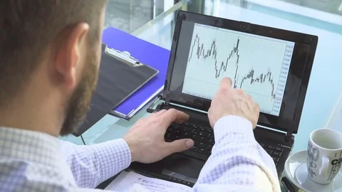 Busienessman analyzing chart on laptop, making notes, office, close behind shot Vídeo Stock 73168090