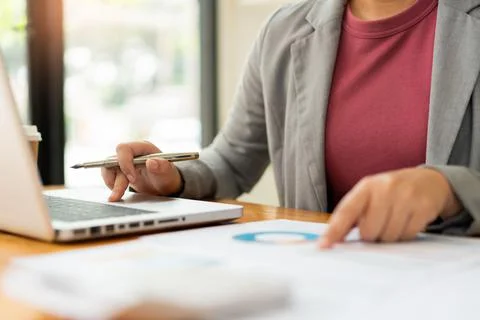 Business analyst concept the data analyst holding and pointing her pen at the Stock Photos