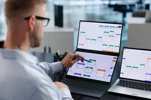 Business Analyst Optimizes Workflow Using No-code Tools On Laptop Screen. Stock Photos