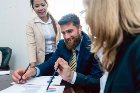 Business analyst smiling while interpreting financial reports sh Stock Photos