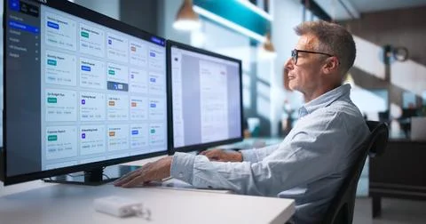 Business Analyst Studies Digital Documents On Computer Improving Workflow Eff Stock Photos