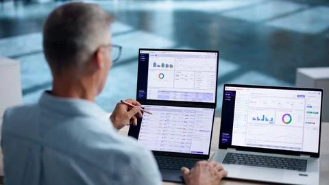 Business Analyst Studies Interactive Dashboards On Dual Touchscreen Laptops C Stock Photos