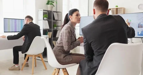 Business analysts collaborating at computers reviewing charts, graphs and data Stock Footage 343551553