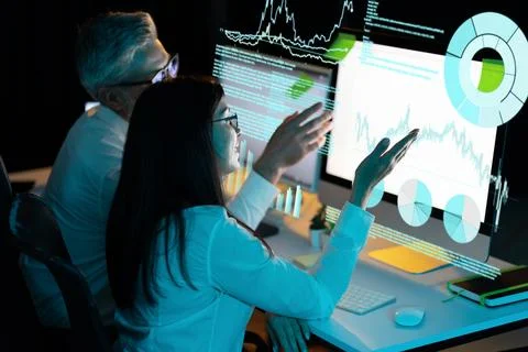 Business Analysts Discussing Data Visualizations on Computer Screens Stock Photos