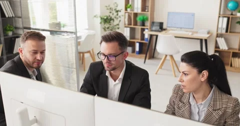 Business analysts team reviewing data on computer screens in modern office Stock Footage 341379683