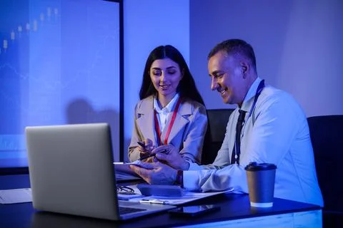Business analysts working at table in dark office. Data science concept Stock Photos