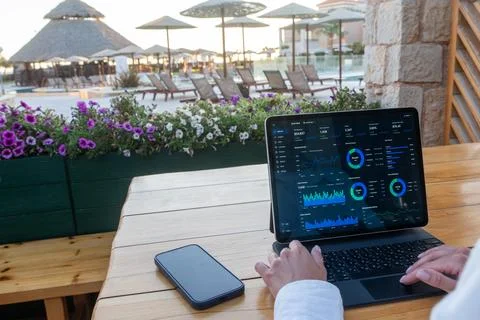 Business Analytics Dashboard on Tablet Screen at Outdoor Resort Terrace Stock-Fotos