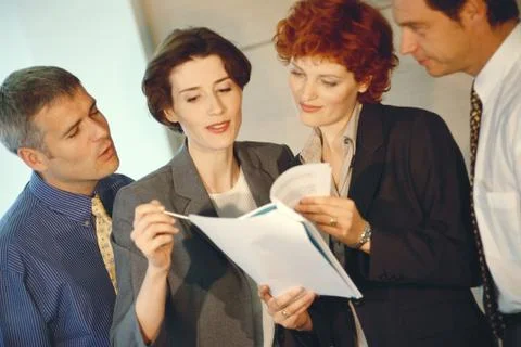 Business associates looking at document Stock Photos