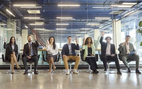 Business audience at training workshop, group raising hands in modern office Fotos Stock