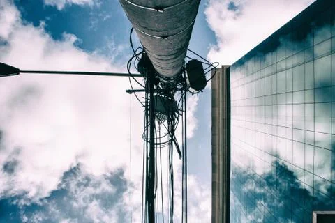 Business building with clouds reflected on the windows and electric pole 스톡 사진