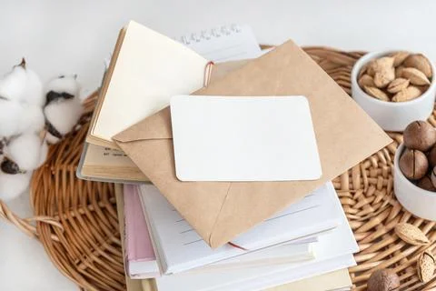 Business card on stack of notebooks with envelope on table Stockfoto's