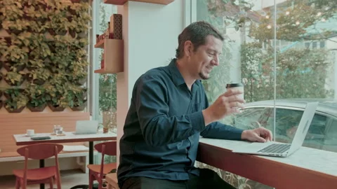 A business caucasian man is using computer video calling to his friend in cof Video stock 171380488