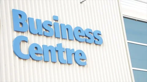Business centre center writing caption text words blue on beige building wall Stock-Footage 251360657
