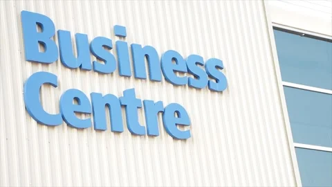 Business centre center writing caption text words blue on beige building wall Video stock 251360862