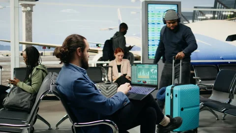 Business CEO evaluating company data and KPIs working on laptop in airport Stock Footage 339643022
