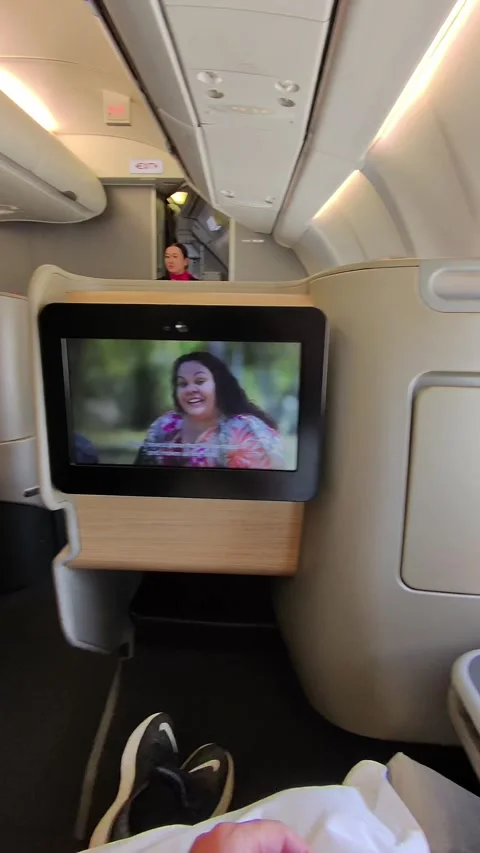 Business Class Passenger Watching Screen Then Looking Out Airplane Window Stock Footage 323780355